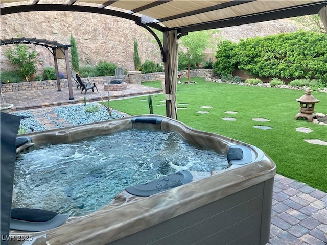 exterior space with a patio area, a jacuzzi, a yard, and a fire pit