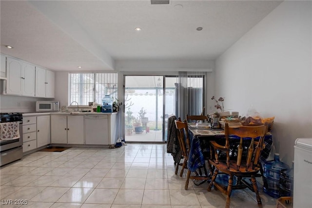 kitchen featuring white appliances, white cabinets, light tile patterned flooring, light countertops, and recessed lighting