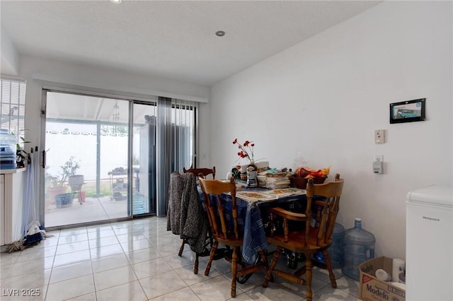 dining room with light tile patterned floors and vaulted ceiling