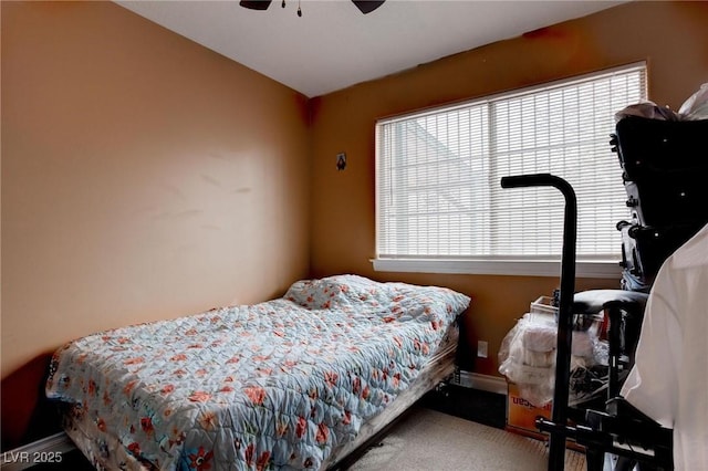 carpeted bedroom with a ceiling fan and baseboards