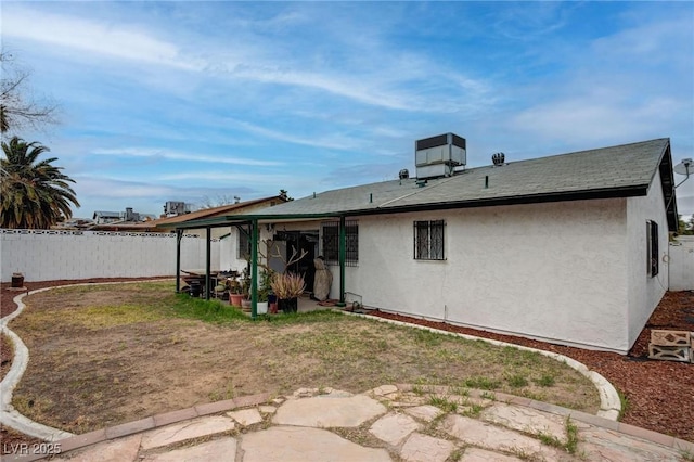 back of property with central AC, fence, a patio, and stucco siding