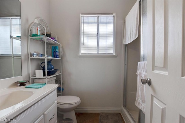 bathroom with baseboards, toilet, tile patterned floors, vanity, and a shower stall