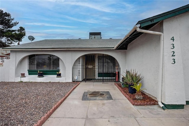 entrance to property with a gate and stucco siding