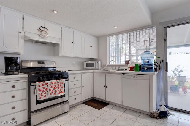 kitchen featuring light countertops, white appliances, white cabinets, and under cabinet range hood