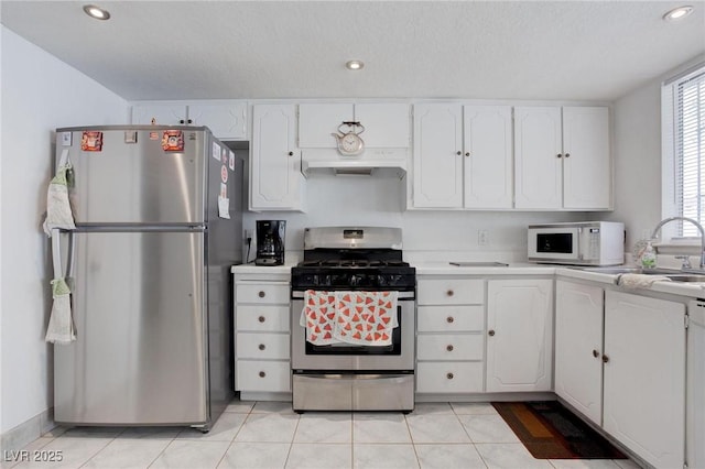 kitchen featuring light countertops, appliances with stainless steel finishes, white cabinets, and under cabinet range hood