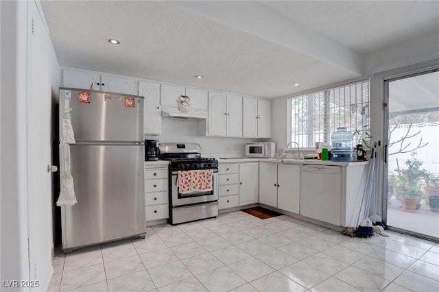 kitchen with recessed lighting, stainless steel appliances, a sink, white cabinets, and light countertops