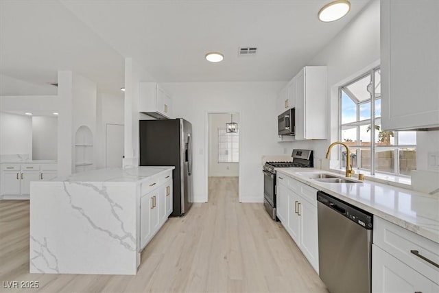 kitchen featuring light wood finished floors, visible vents, white cabinets, appliances with stainless steel finishes, and a sink