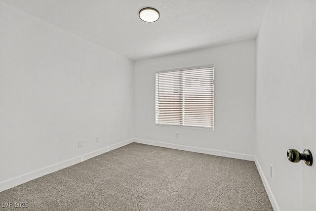 spare room with carpet and baseboards