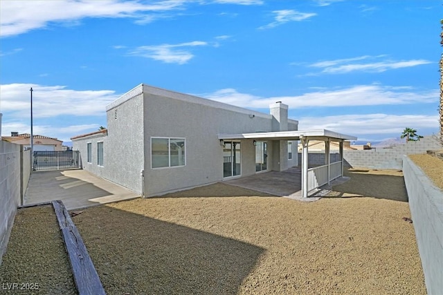 back of property with a patio area, a fenced backyard, and stucco siding