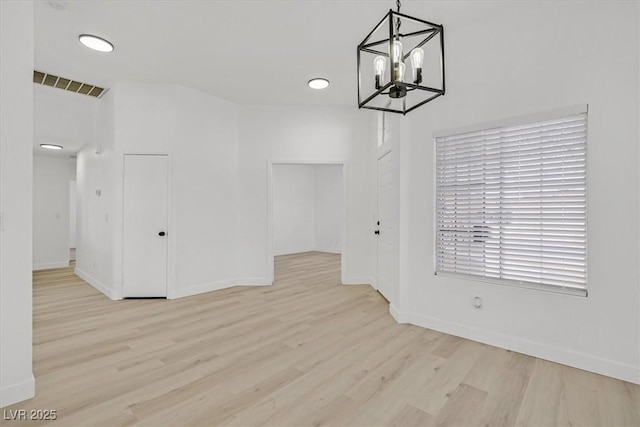 unfurnished dining area featuring wood finished floors, visible vents, and baseboards