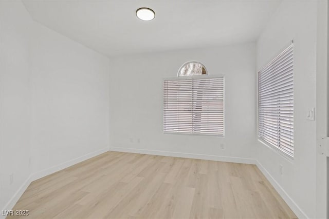 empty room featuring light wood-style flooring and baseboards