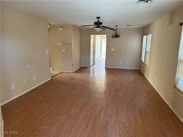 unfurnished living room featuring light wood finished floors, ceiling fan, visible vents, and baseboards