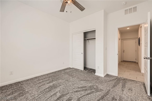 unfurnished bedroom featuring carpet, a closet, visible vents, ceiling fan, and baseboards