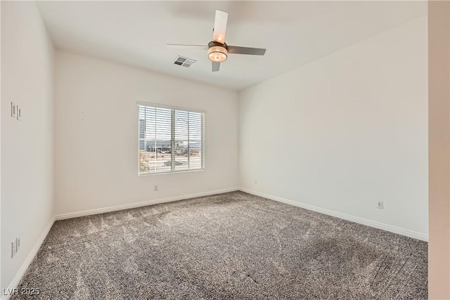 carpeted empty room featuring a ceiling fan, visible vents, and baseboards