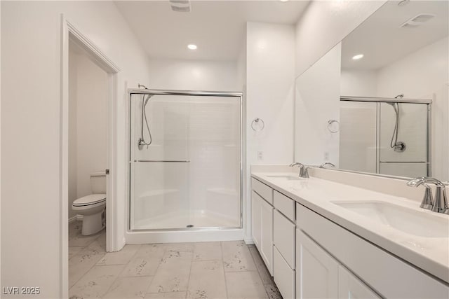 bathroom featuring toilet, a shower stall, and a sink