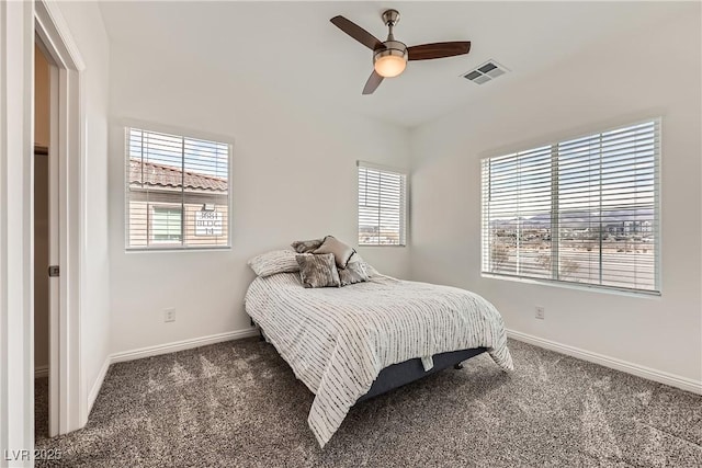 carpeted bedroom with ceiling fan, multiple windows, visible vents, and baseboards