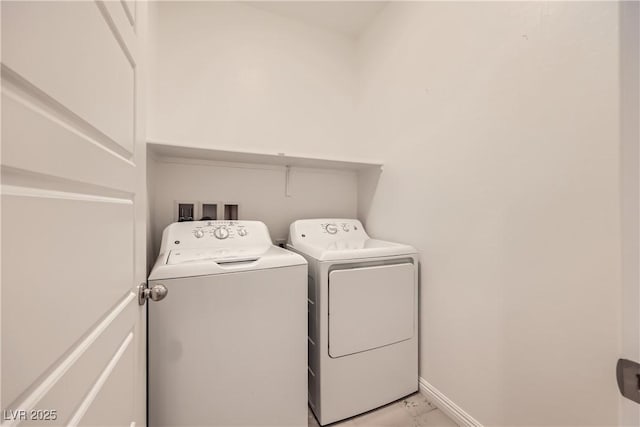 laundry area featuring washing machine and dryer, laundry area, marble finish floor, and baseboards