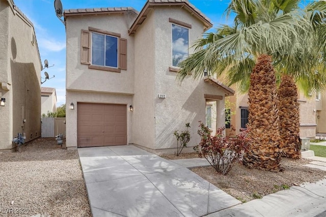 view of front facade with an attached garage, driveway, fence, and stucco siding