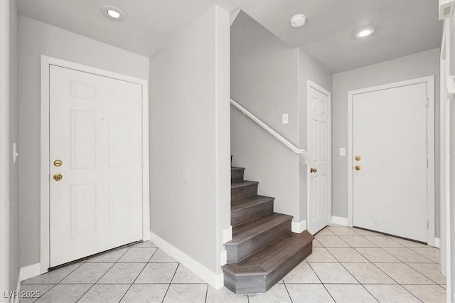 entryway featuring light tile patterned floors, baseboards, stairway, and recessed lighting