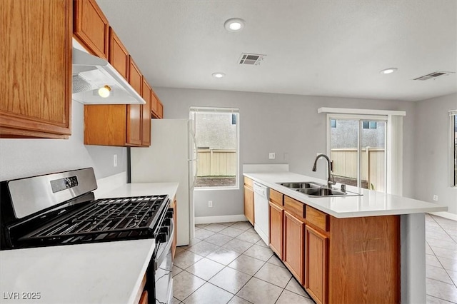 kitchen with white appliances, a sink, visible vents, and under cabinet range hood