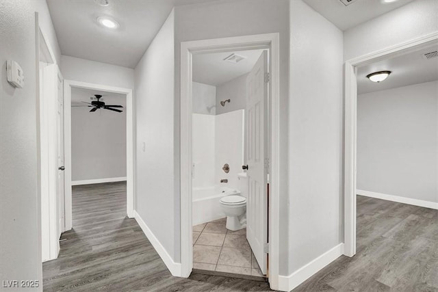 bathroom with  shower combination, toilet, baseboards, and wood finished floors