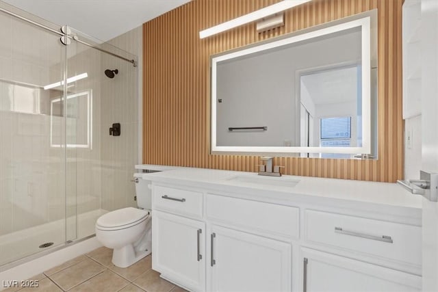 bathroom with toilet, vanity, tile patterned floors, a stall shower, and wallpapered walls