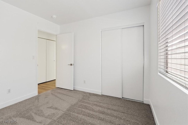 unfurnished bedroom featuring a closet, carpet flooring, and baseboards