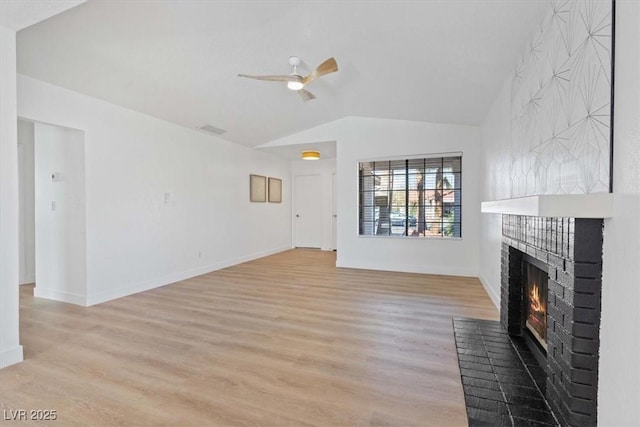 unfurnished living room featuring visible vents, a ceiling fan, light wood-style floors, vaulted ceiling, and a brick fireplace