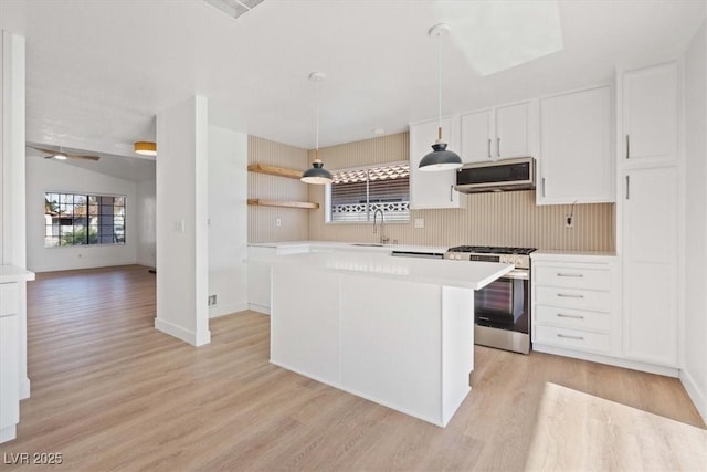 kitchen with stainless steel appliances, a sink, light countertops, a center island, and open shelves