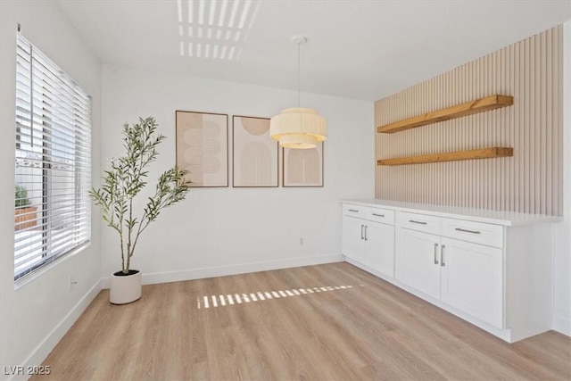 interior space featuring light wood-type flooring and baseboards