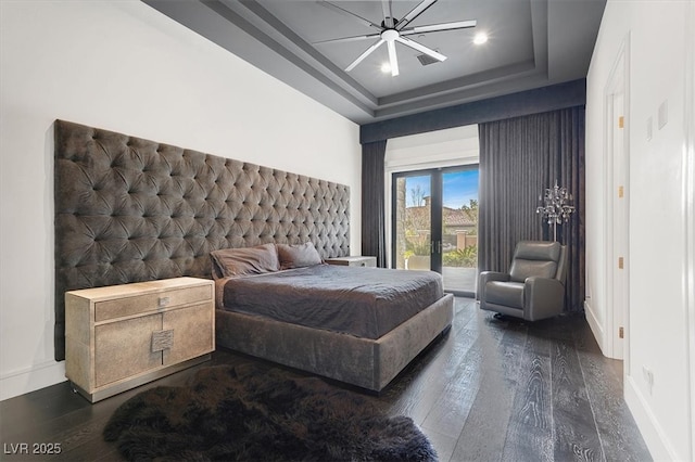 bedroom featuring baseboards, a raised ceiling, hardwood / wood-style flooring, access to outside, and french doors