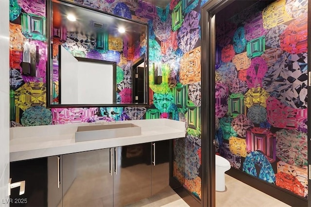 bathroom featuring toilet, wallpapered walls, visible vents, and vanity