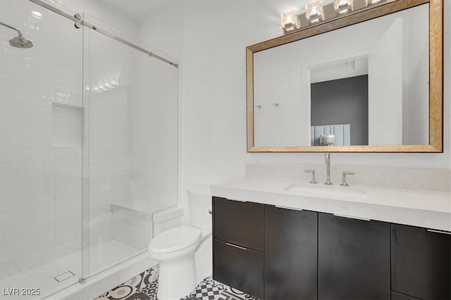 bathroom featuring toilet, a shower stall, and vanity