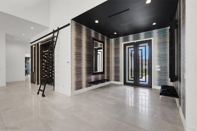 foyer entrance featuring recessed lighting, french doors, baseboards, and wallpapered walls