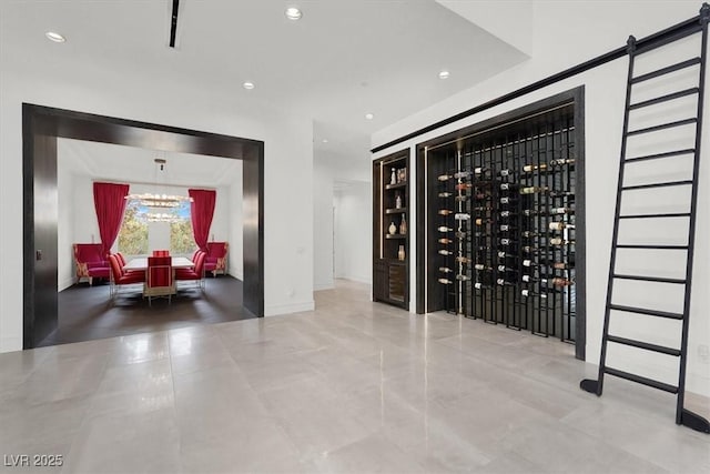 wine cellar featuring an inviting chandelier, baseboards, and recessed lighting