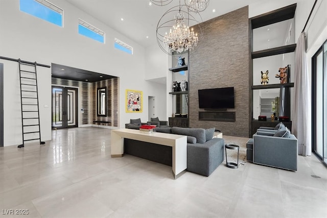 living room featuring built in shelves, french doors, a high ceiling, an inviting chandelier, and tile patterned floors