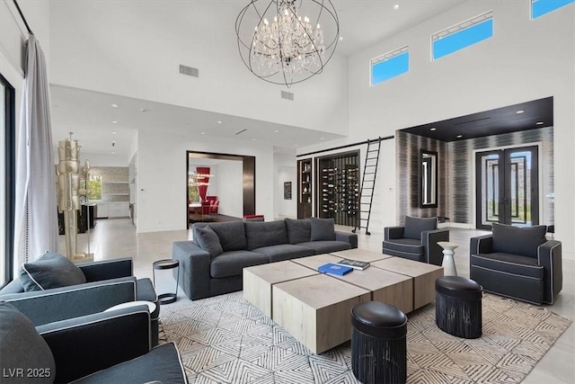 living area featuring recessed lighting, a towering ceiling, visible vents, french doors, and an inviting chandelier