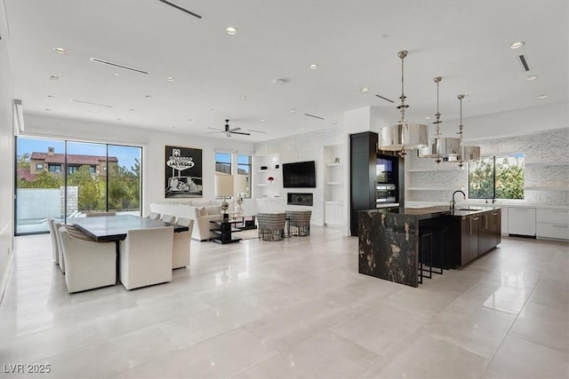 kitchen featuring decorative backsplash, a spacious island, modern cabinets, a sink, and recessed lighting