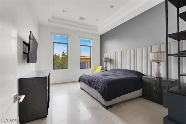 bedroom featuring a tray ceiling, visible vents, baseboards, and light tile patterned floors