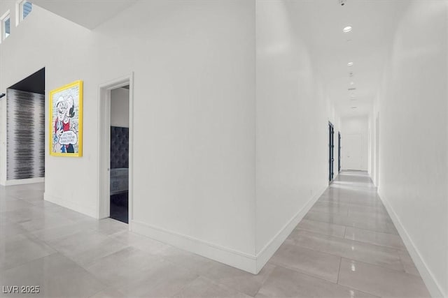 corridor featuring baseboards and recessed lighting