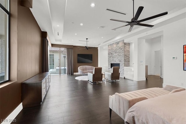 bedroom with recessed lighting, visible vents, a stone fireplace, baseboards, and hardwood / wood-style flooring