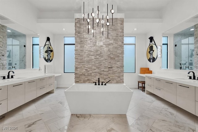 bathroom with a shower stall, marble finish floor, a sink, and a healthy amount of sunlight