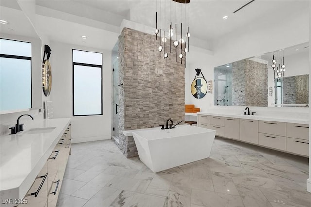 bathroom featuring a soaking tub, a shower stall, marble finish floor, and a sink