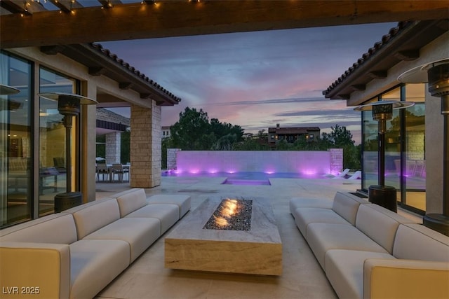 view of pool with a patio and an outdoor living space with a fire pit