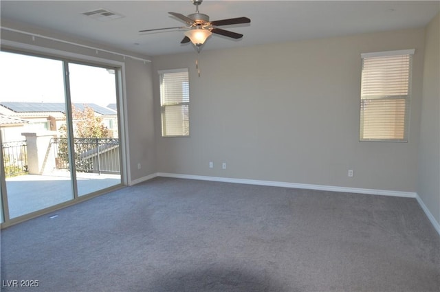 carpeted spare room featuring a ceiling fan, visible vents, and baseboards