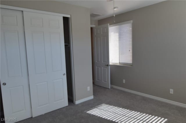 unfurnished bedroom featuring a closet, carpet flooring, visible vents, and baseboards