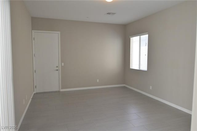 unfurnished room with visible vents and baseboards