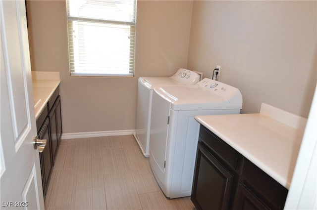 laundry area featuring cabinet space, baseboards, and separate washer and dryer