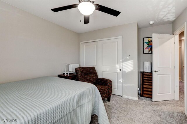 bedroom with baseboards, light colored carpet, a closet, and ceiling fan