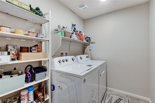 clothes washing area with washer and dryer, laundry area, visible vents, and baseboards